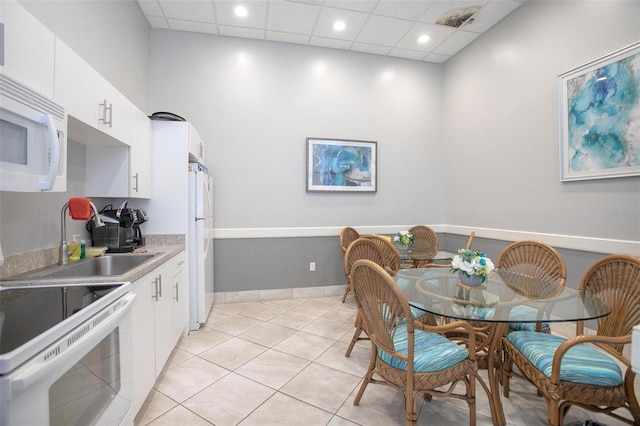 3043 S Atlantic Ave Unit 204, Daytona Beach, FL 32118 - kitchen featuring white appliances, white cabinets, light tile patterned floors, light countertops, and recessed lighting