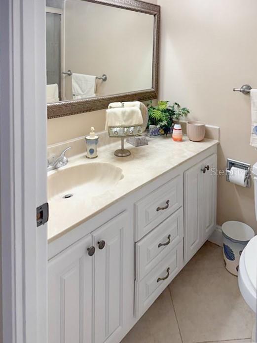 3043 S Atlantic Ave Unit 204, Daytona Beach, FL 32118 - bathroom with toilet, vanity, tile patterned floors, and a shower with door
