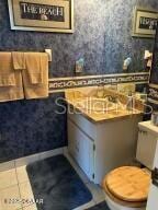 2898 Ocean Shore Blvd Unit 603, Ormond Beach, FL 32176 - bathroom with wallpapered walls, toilet, and tile patterned floors