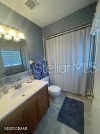 2898 Ocean Shore Blvd Unit 603, Ormond Beach, FL 32176 - full bathroom featuring vanity, toilet, and a shower with shower curtain