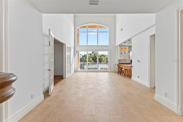 2275 Genesea Ln, Vero Beach, FL 32963 - unfurnished living room with baseboards and a towering ceiling