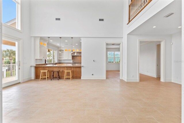 2275 Genesea Ln, Vero Beach, FL 32963 - unfurnished living room with a high ceiling, plenty of natural light, baseboards, and recessed lighting