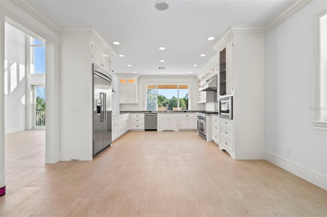 2275 Genesea Ln, Vero Beach, FL 32963 - kitchen with built in appliances, under cabinet range hood, crown molding, white cabinets, and recessed lighting