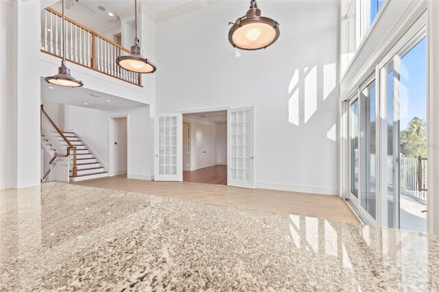 2275 Genesea Ln, Vero Beach, FL 32963 - unfurnished living room with french doors, a towering ceiling, stairway, baseboards, and tile patterned flooring