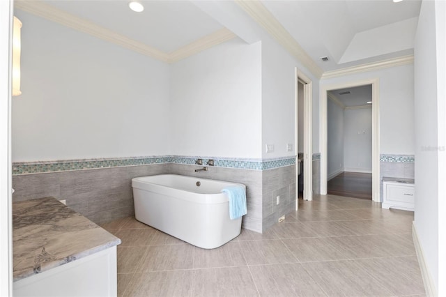 2275 Genesea Ln, Vero Beach, FL 32963 - bathroom with tile walls, wainscoting, ornamental molding, a freestanding tub, and vanity