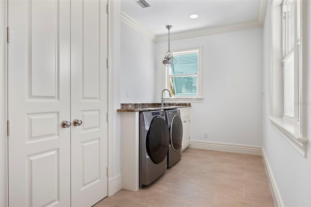 2275 Genesea Ln, Vero Beach, FL 32963 - laundry area with separate washer and dryer, cabinet space, crown molding, baseboards, and bar with sink