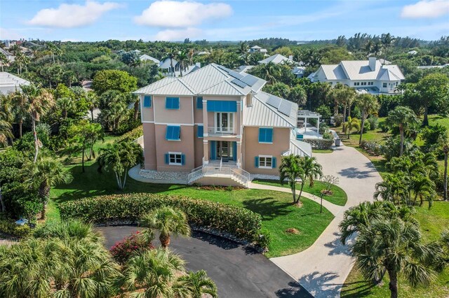 2275 Genesea Ln, Vero Beach, FL 32963 - view of front facade featuring a standing seam roof, a front yard, metal roof, stucco siding, and driveway