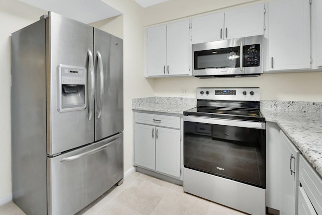 600 N Boundary Ave Unit 110A, Deland, FL 32720 - kitchen featuring stainless steel appliances, light tile patterned floors, light stone counters, and white cabinetry