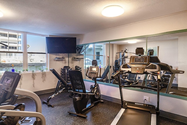 2800 N Atlantic Ave Unit 1716, Daytona Beach, FL 32118 - exercise room featuring a textured ceiling and baseboards
