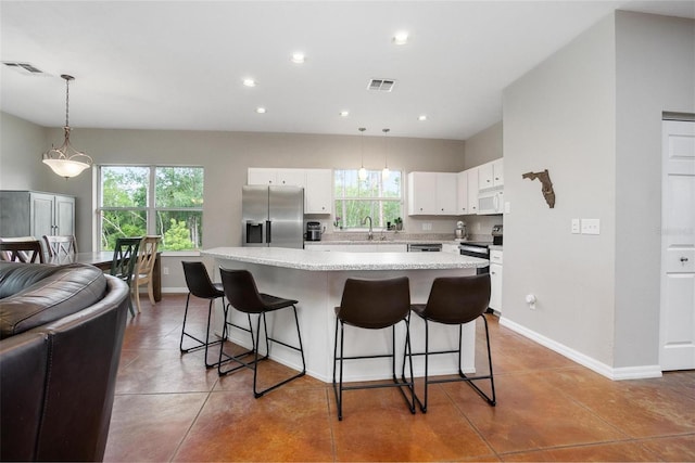 3671 Plantation Dr, Ormond Beach, FL 32174 - kitchen with appliances with stainless steel finishes, a breakfast bar area, healthy amount of natural light, recessed lighting, and light countertops