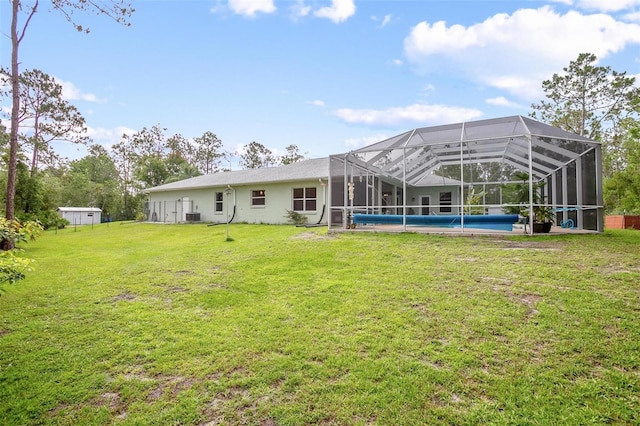 3671 Plantation Dr, Ormond Beach, FL 32174 - rear view of property featuring a yard, an outdoor pool, glass enclosure, and stucco siding