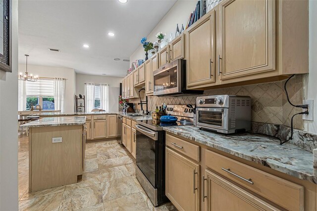 45 Saint Andrews Ct, Palm Coast, FL 32137 - kitchen featuring appliances with stainless steel finishes, light brown cabinets, a peninsula, recessed lighting, and light stone countertops