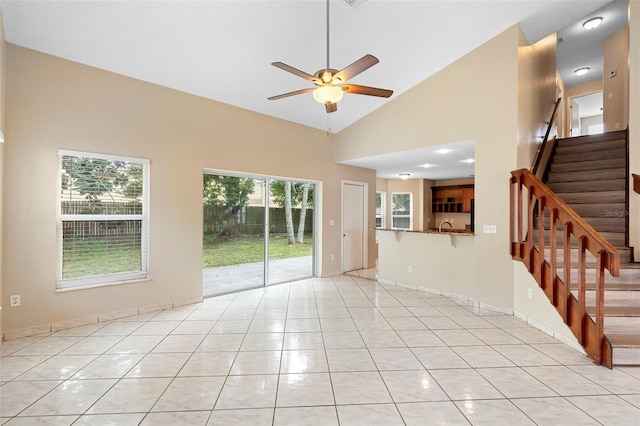 2708 Smithfield Dr, Orlando, FL 32837 - unfurnished living room featuring ceiling fan, stairs, light tile patterned flooring, and high vaulted ceiling