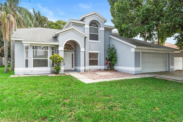 2708 Smithfield Dr, Orlando, FL 32837 - view of front of house with a front lawn, stucco siding, driveway, a shingled roof, and a garage