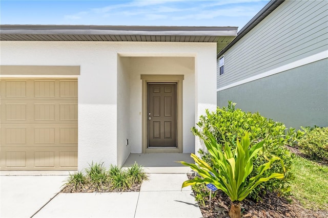 2241 Litchfield Loop, Deland, FL 32720 - doorway to property featuring stucco siding and a garage