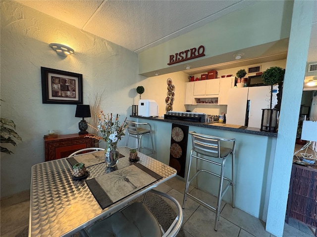 411 N Halifax Ave Unit 208, Daytona Beach, FL 32118 - dining area featuring tile patterned floors, a textured wall, and a textured ceiling