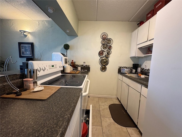411 N Halifax Ave Unit 208, Daytona Beach, FL 32118 - kitchen featuring white electric stove, dark countertops, a textured ceiling, white cabinets, and light tile patterned floors