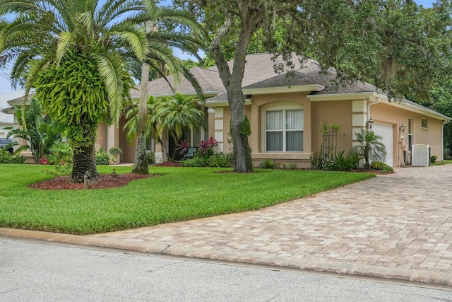 33 Coquina Ridge Way, Ormond Beach, FL 32174 - view of front of home featuring stucco siding, a garage, decorative driveway, and a front lawn