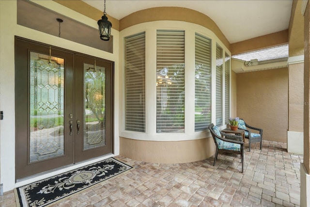 33 Coquina Ridge Way, Ormond Beach, FL 32174 - doorway to property with french doors, stucco siding, and covered porch