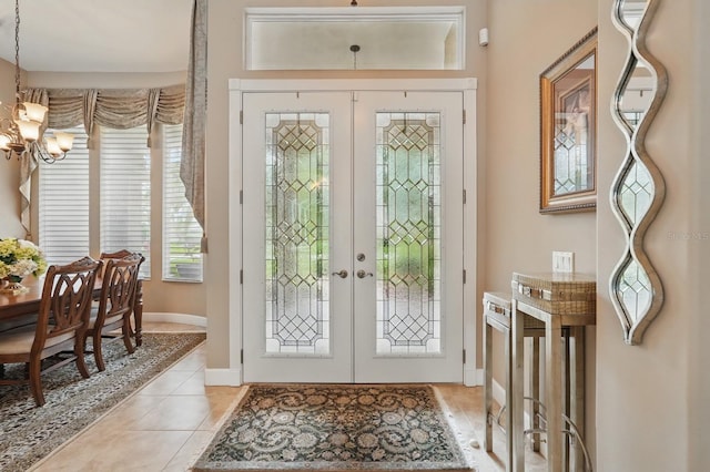 33 Coquina Ridge Way, Ormond Beach, FL 32174 - entryway featuring french doors, a chandelier, light tile patterned flooring, and baseboards