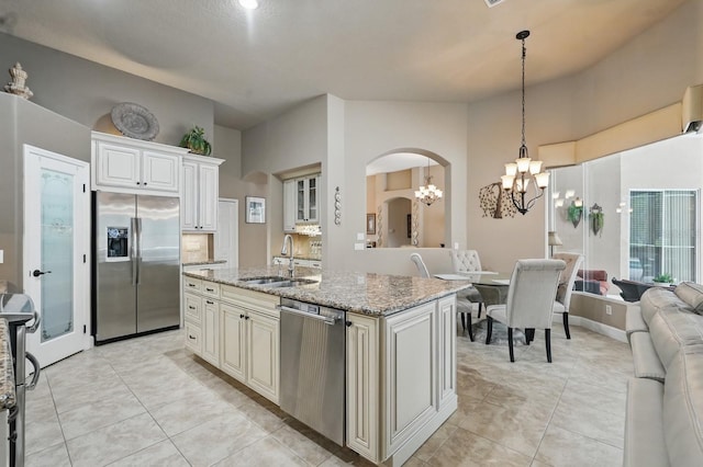 33 Coquina Ridge Way, Ormond Beach, FL 32174 - kitchen with appliances with stainless steel finishes, a sink, a chandelier, light stone counters, and open floor plan