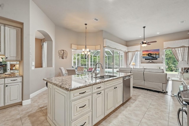 33 Coquina Ridge Way, Ormond Beach, FL 32174 - kitchen featuring a sink, stainless steel dishwasher, arched walkways, light stone countertops, and light tile patterned floors