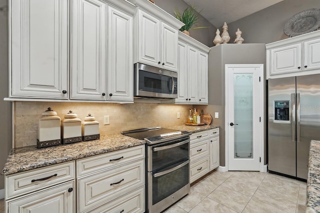 33 Coquina Ridge Way, Ormond Beach, FL 32174 - kitchen with stainless steel appliances, decorative backsplash, light stone countertops, and light tile patterned floors