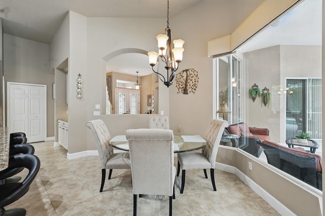 33 Coquina Ridge Way, Ormond Beach, FL 32174 - dining area with arched walkways, a chandelier, baseboards, and light tile patterned floors