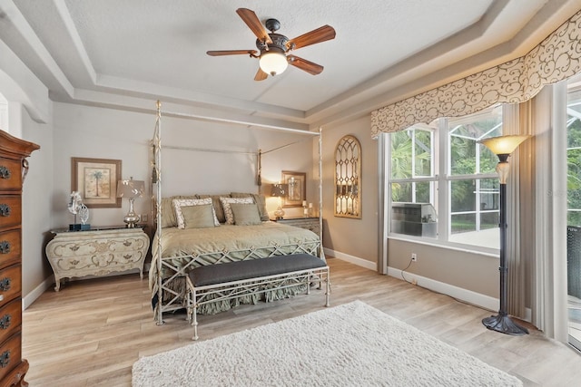33 Coquina Ridge Way, Ormond Beach, FL 32174 - bedroom featuring a raised ceiling, wood finished floors, baseboards, ceiling fan, and cooling unit
