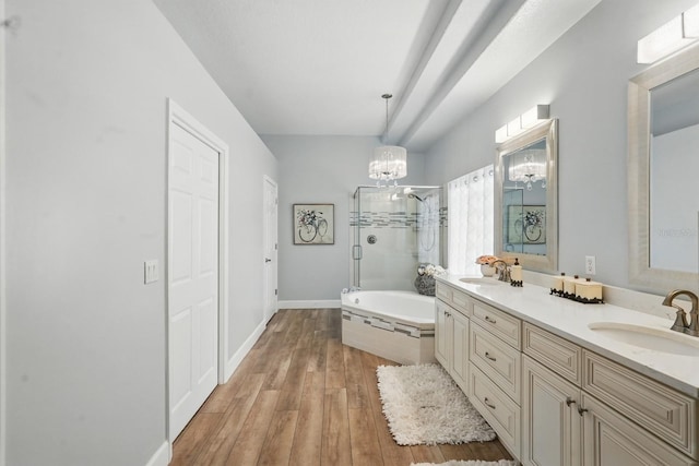 33 Coquina Ridge Way, Ormond Beach, FL 32174 - bathroom with a chandelier, a stall shower, a garden tub, double vanity, and wood finished floors