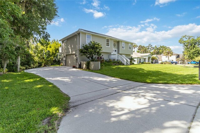 2250 Davis Dr, New Smyrna Beach, FL 32168 - split foyer home featuring a garage, concrete driveway, and a front yard