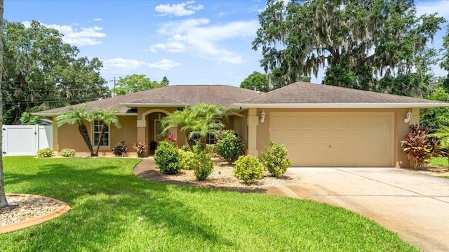 3132 Mango Tree Dr, Edgewater, FL 32141 - ranch-style house featuring stucco siding, a garage, driveway, and a gate
