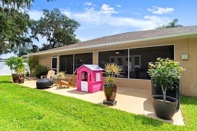 3132 Mango Tree Dr, Edgewater, FL 32141 - rear view of house featuring a sunroom, a patio, a yard, and stucco siding