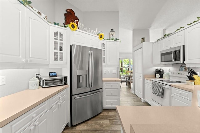 3132 Mango Tree Dr, Edgewater, FL 32141 - kitchen featuring stainless steel appliances, dark wood finished floors, glass insert cabinets, and white cabinets