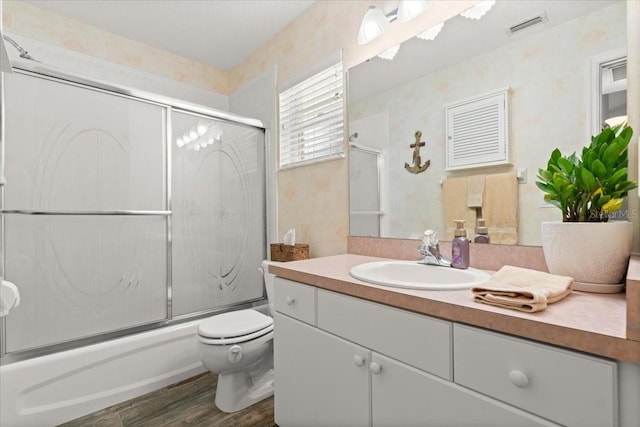 3132 Mango Tree Dr, Edgewater, FL 32141 - bathroom featuring vanity, bath / shower combo with glass door, wallpapered walls, and wood finished floors