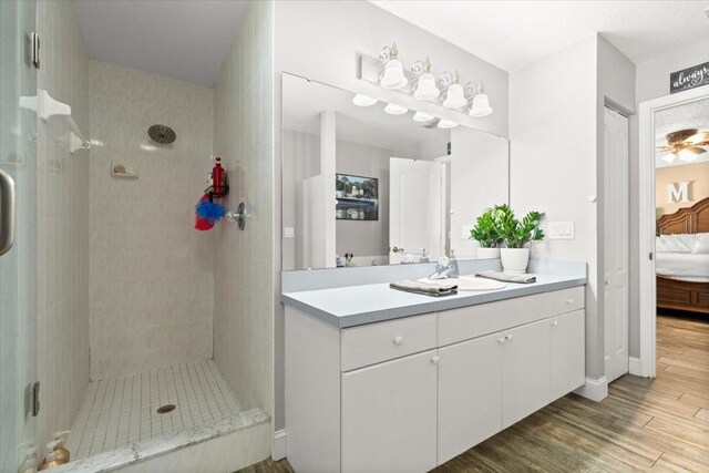3132 Mango Tree Dr, Edgewater, FL 32141 - ensuite bathroom with vanity, tiled shower, and wood finished floors