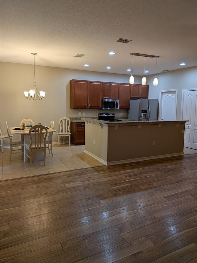 223 W Fiesta Key Loop, Deland, FL 32720 - kitchen featuring stainless steel appliances, dark wood-style flooring, recessed lighting, pendant lighting, and a chandelier