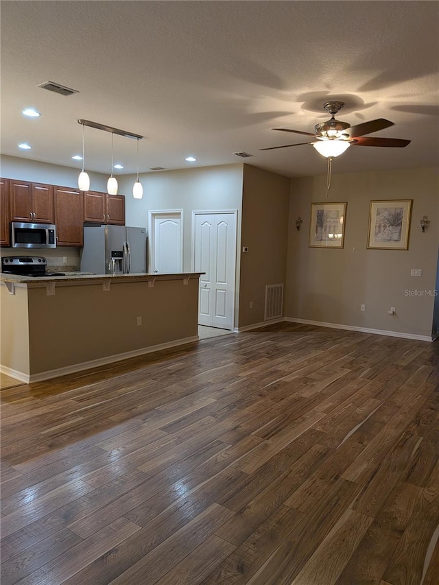 223 W Fiesta Key Loop, Deland, FL 32720 - kitchen with appliances with stainless steel finishes, dark wood-type flooring, a kitchen bar, ceiling fan, and open floor plan