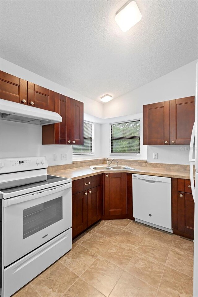 1018 E Gaucho Cir, Deltona, FL 32725 - kitchen with white appliances, a sink, under cabinet range hood, light countertops, and a textured ceiling