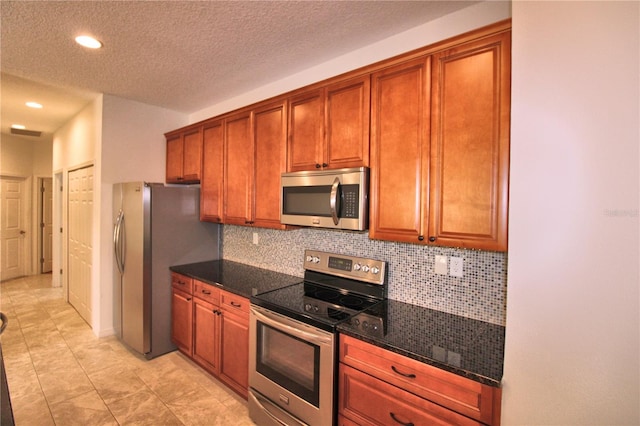 201 Walter Stevens Way, Deland, FL 32724 - kitchen featuring stainless steel appliances, decorative backsplash, brown cabinets, dark stone counters, and recessed lighting