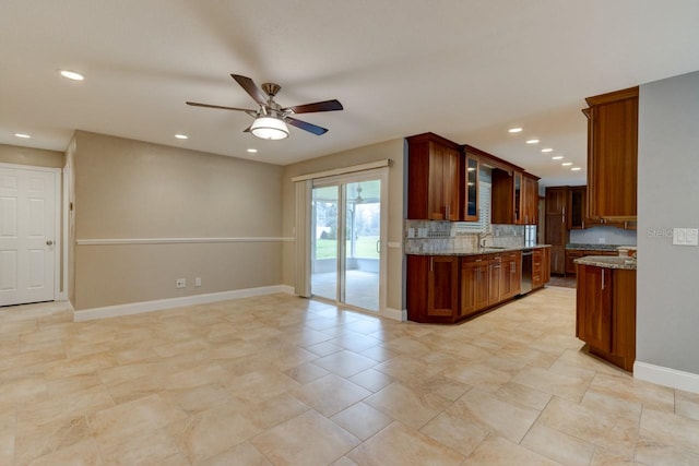 65 Sycamore Cir, Ormond Beach, FL 32174 - kitchen with dishwasher, a sink, light stone counters, ceiling fan, and baseboards