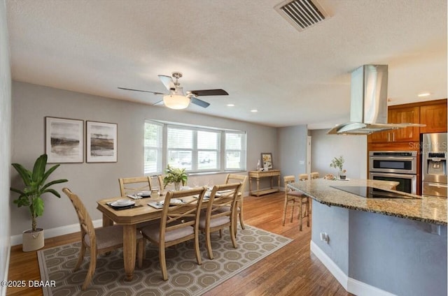 65 Sycamore Cir, Ormond Beach, FL 32174 - dining area with a ceiling fan, light wood finished floors, baseboards, and a textured ceiling