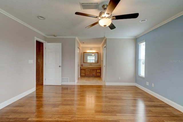 65 Sycamore Cir, Ormond Beach, FL 32174 - unfurnished bedroom with light wood finished floors, crown molding, baseboards, ensuite bath, and a sink
