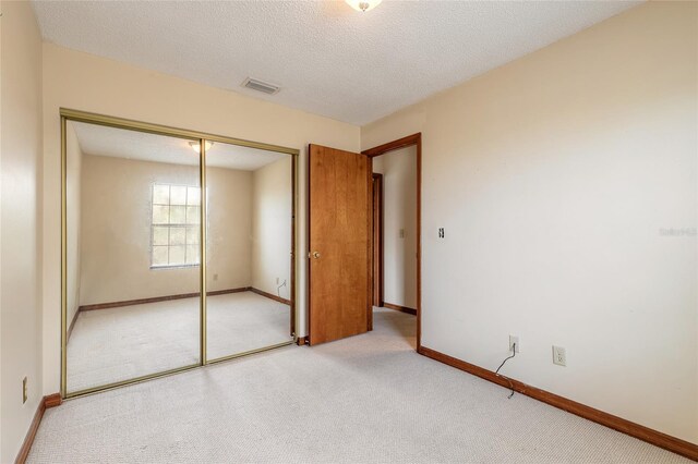 840 Center Ave Unit 280, Daytona Beach, FL 32117 - unfurnished bedroom featuring light carpet, a closet, and a textured ceiling