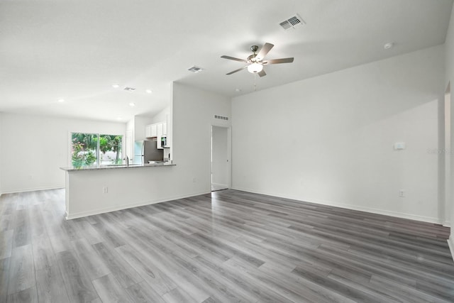 1161 Kenway Ave, Deltona, FL 32738 - unfurnished living room with ceiling fan, light wood finished floors, lofted ceiling, recessed lighting, and baseboards