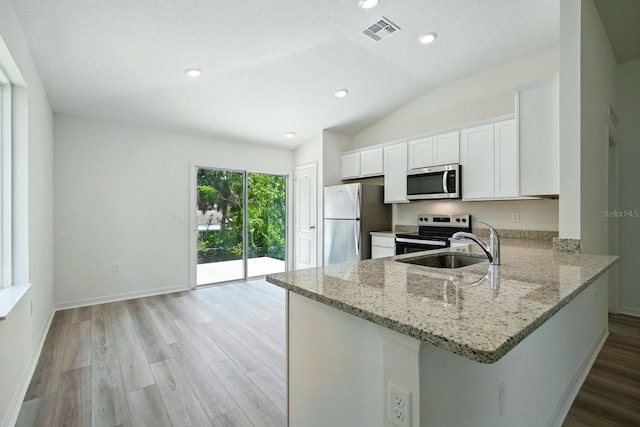 1161 Kenway Ave, Deltona, FL 32738 - kitchen with stainless steel appliances, light stone counters, vaulted ceiling, white cabinetry, and a peninsula