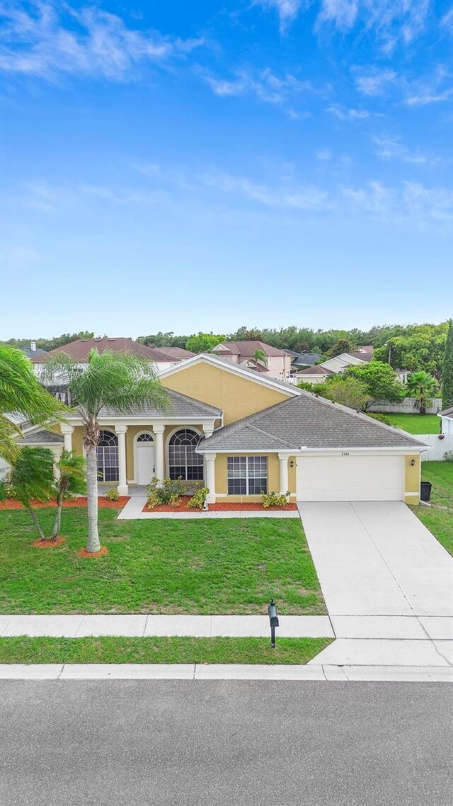 2263 Catbriar Way, Oviedo, FL 32765 - view of front facade featuring a garage, a front lawn, driveway, and stucco siding