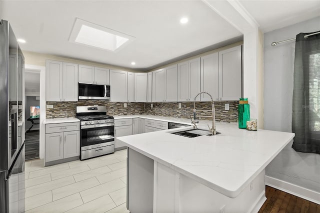 812 Faulkner St, New Smyrna Beach, FL 32168 - kitchen featuring appliances with stainless steel finishes, a peninsula, tasteful backsplash, light stone counters, and recessed lighting