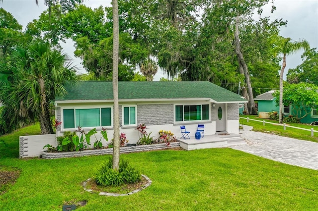 812 Faulkner St, New Smyrna Beach, FL 32168 - view of front of home with a front yard and a shingled roof