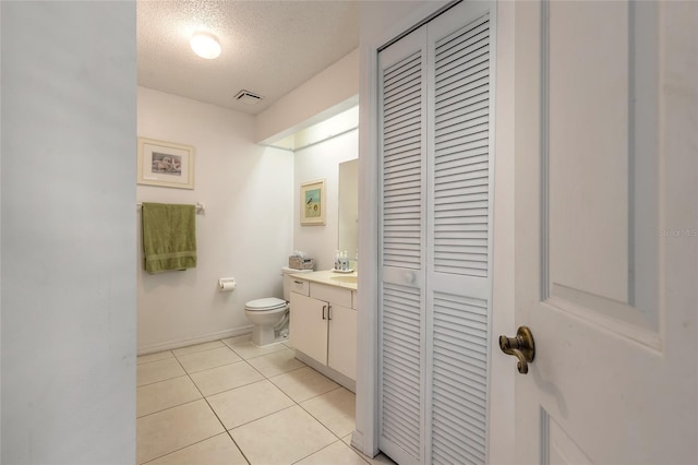 961 S Lakewood Ter Unit C, Port Orange, FL 32127 - bathroom with a closet, vanity, a textured ceiling, and tile patterned floors